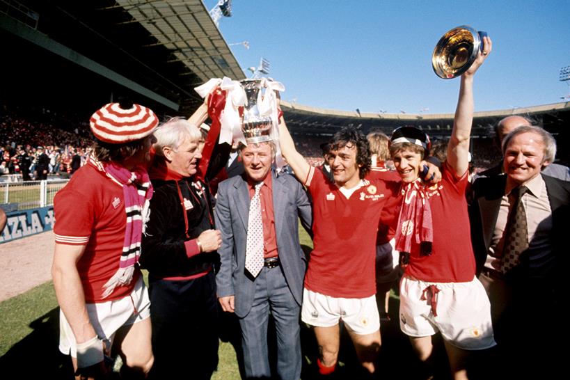 1977 FA Cup Final - Liverpool vs Manchester United - Wembley Stadium. Manchester United Manager Tommy Docherty (centre) celebrates the FA Cup with Lou Macari (third right) and Gordon Hill (second right). Photo: PA Images / Alamy Stock Fto